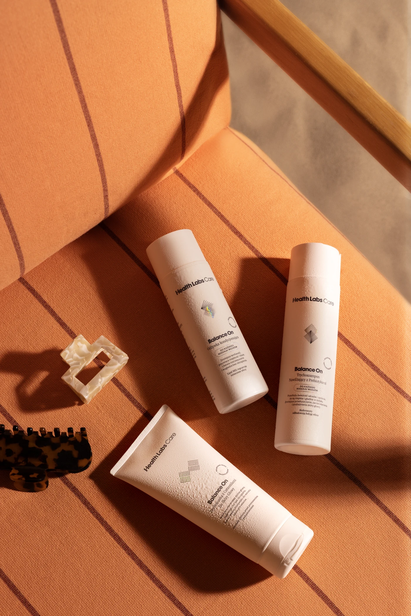 Balance On shampoo, conditioner and scalp scrub on a sunlit orange chair